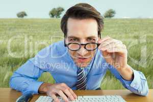 Composite image of focused businessman holding his glasses