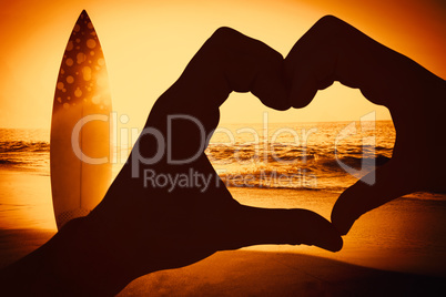 Composite image of couple making heart shape with hands