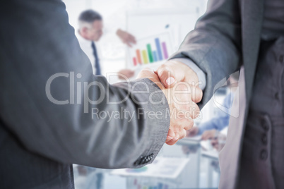 Composite image of business people shaking hands close up