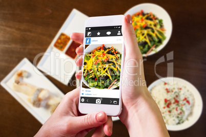 Composite image of hand holding smartphone