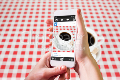 Composite image of hand holding smartphone