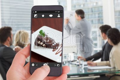 Composite image of female hand holding a smartphone