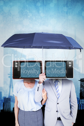 Composite image of business people holding a black umbrella