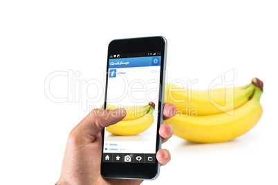 Composite image of hand holding smartphone