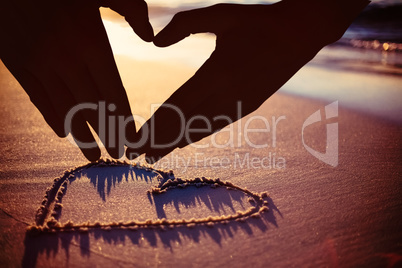 Composite image of woman making heart shape with hands