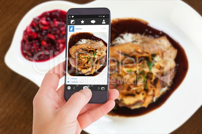 Composite image of female hand holding a smartphone