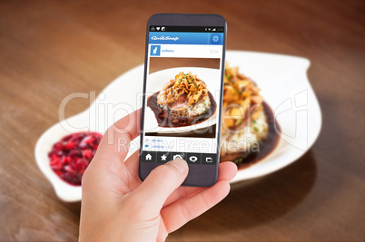 Composite image of female hand holding a smartphone