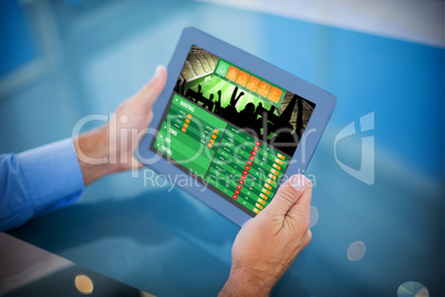 Composite image of businessman using his tablet