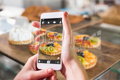 Composite image of hand holding smartphone