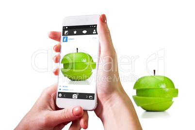 Composite image of hand holding smartphone