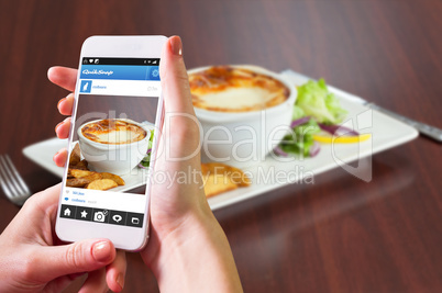 Composite image of hand holding smartphone