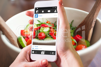 Composite image of hand holding smartphone