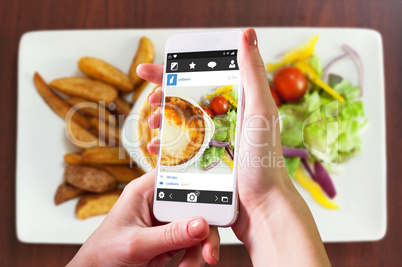 Composite image of hand holding smartphone