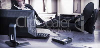 Warehouse manager using telephone at desk