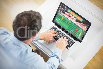 Composite image of man using laptop