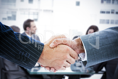 Composite image of business people shaking hands