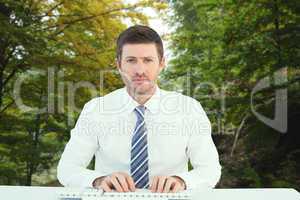 Composite image of businessman working at his desk