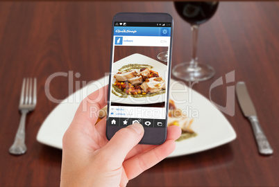 Composite image of female hand holding a smartphone