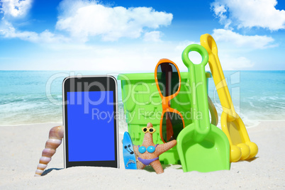 Smartphone, Sonnenbrille und Spiezeug am Strand