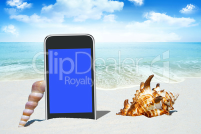 Schwarzes Smartphone und Muscheln am Sandstrand