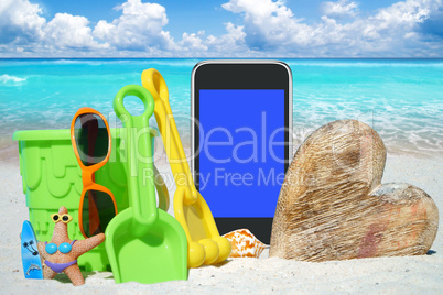 Schwarzes Smartphone, Sonnenbrille und Spiezeug am Strand