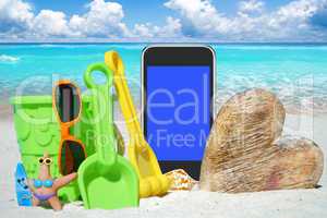 Schwarzes Smartphone, Sonnenbrille und Spiezeug am Strand