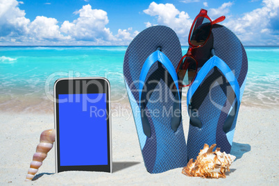 Smartphone, Flip Flops und Sonnenbrille am Strand