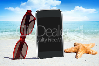 Schwarzes Smartphone, Sonnenbrille und Seestern am Strand
