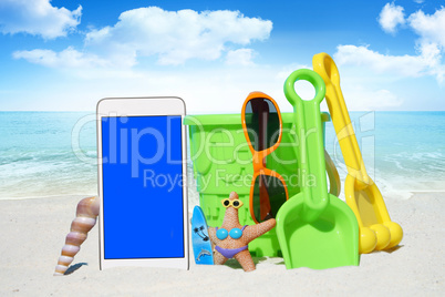 Weißes Smartphone, Sonnenbrille und Spiezeug am Strand