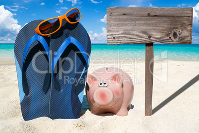 Sparschwein, Flips Flops und leeres Holzschild am Strand