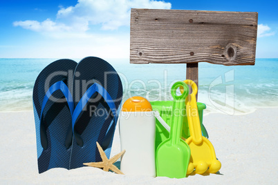 Flip Flops, Sonnenmilch, Spielzeug und leeres Holzschild