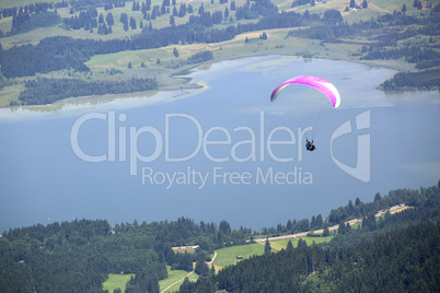 Paraglider flying over Bavarian lake