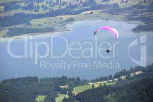 Paraglider flying over Bavarian lake