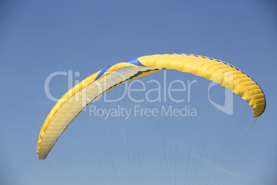 Yellow paraglider with blue sky