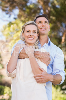 Smiling standing couple embracing and enjoying the view