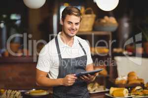 Handsome waiter holding a tablet