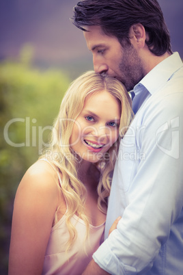 Young happy man kissing woman on the forehead