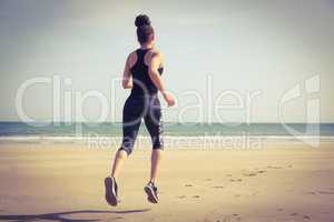 Fit woman jogging on the sand