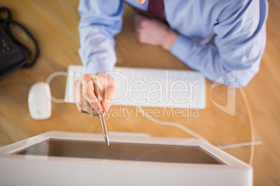 Businessman pointing to screen with pen