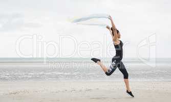 Fit girl leaping with scarf