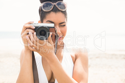 Pretty hipster in bikini taking picture