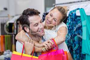 Smiling couple with shopping bags embracing