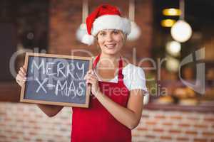 Pretty waitress with a chalkboard merry x-mas