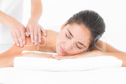 Attractive woman receiving shoulder massage at spa center