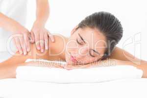 Attractive woman receiving shoulder massage at spa center