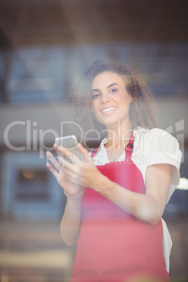 Smiling waitress sending a text