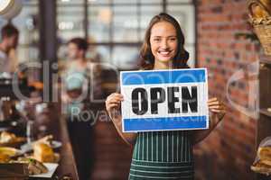 Pretty waitress posing with open sign