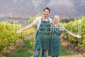 Two young happy vintners showing their fields