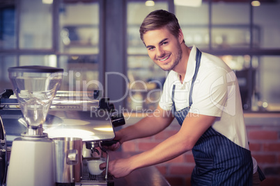 Handsome barista making a cup of coffee