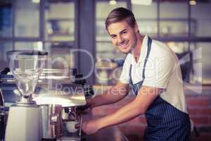 Handsome barista making a cup of coffee